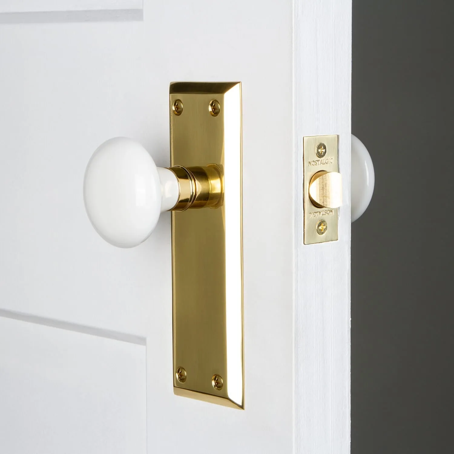 New York Long Plate with White Porcelain Knob in Polished Brass